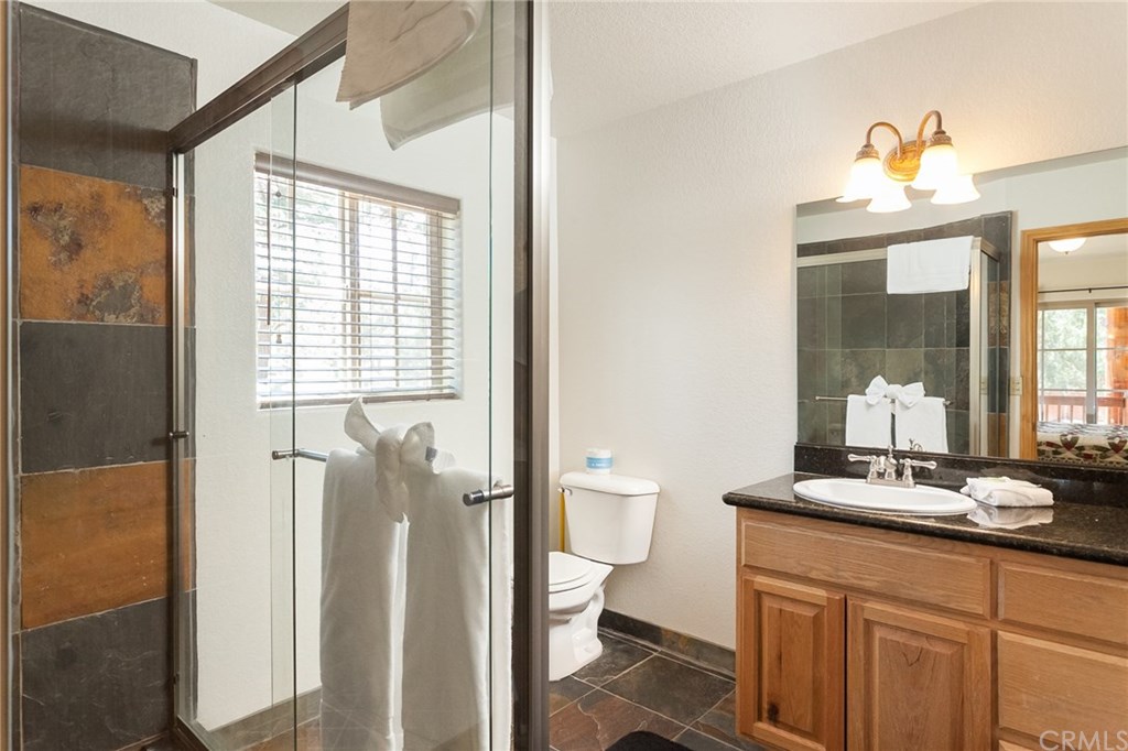 209 Rodeo Road Big Bear City, CA 92314 - Photo 32 of 39 a bathroom with a sink a toilet and a mirror
