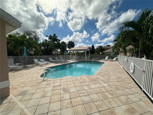 a view of a swimming pool with a lounge chairs in a patio
