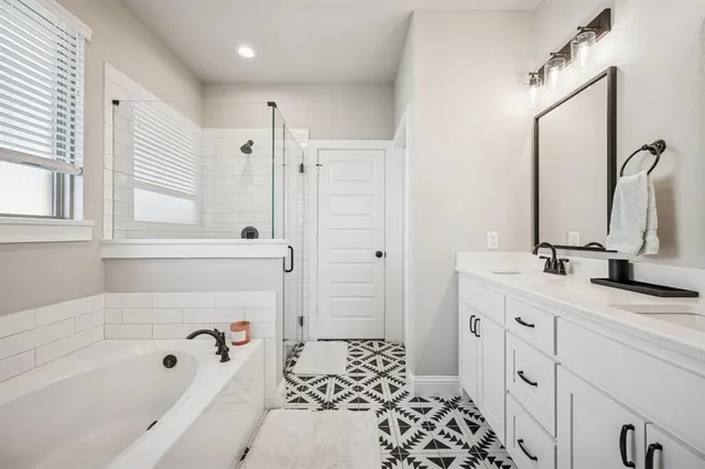 a bathroom with a tub sink and mirror