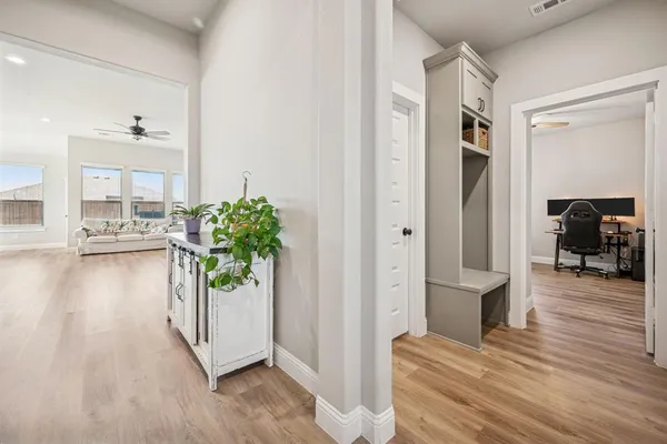a view of a hallway with wooden floor and a living room