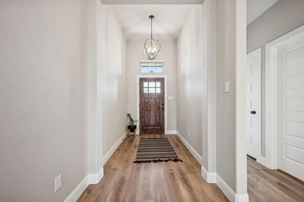 a view of a hallway with wooden floor and a window