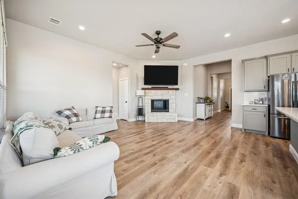 a living room with furniture a flat screen tv and a fireplace