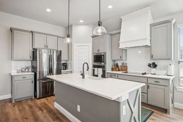 a kitchen with kitchen island a sink stainless steel appliances and cabinets