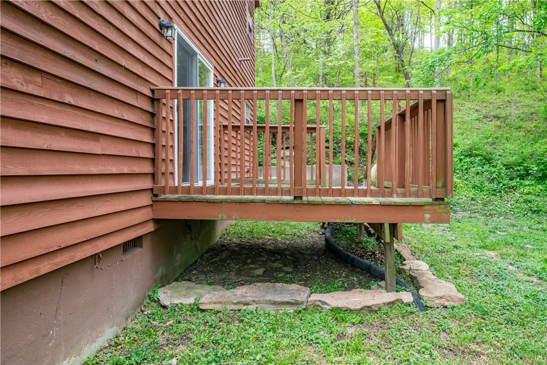 10584 New Biddinger Road Harrison, OH 45030 - Photo 50 of 61 An inviting deck extends from the house, offering a serene outdoor retreat amidst lush greenery.