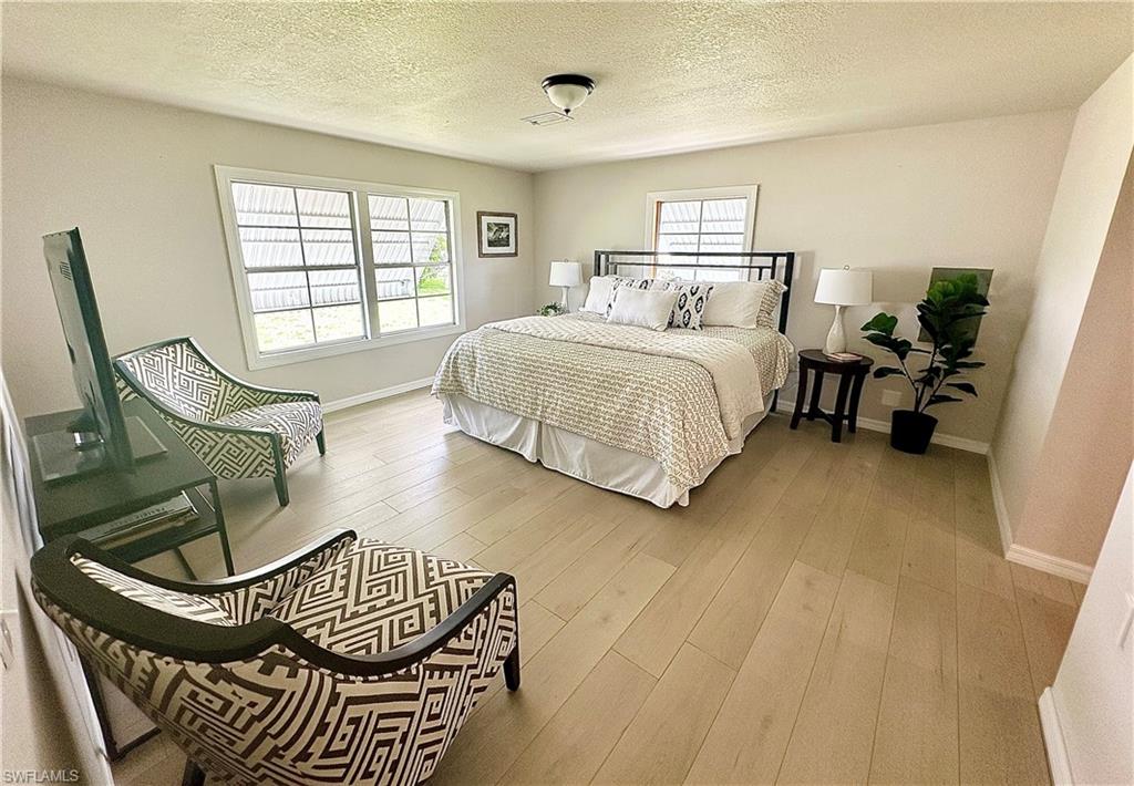 26261 Colony Road Bonita Springs, FL 34135 - Photo 7 of 31 Bedroom featuring hardwood / wood-style flooring and a textured ceiling
