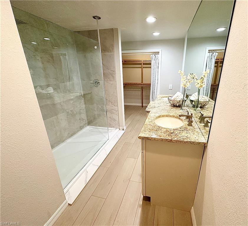 26261 Colony Road Bonita Springs, FL 34135 - Photo 10 of 31 Bathroom with wood-type flooring, a shower with shower door, and vanity