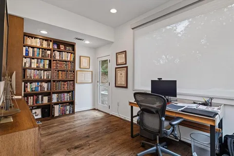 a view of a workspace with furniture and wooden floor