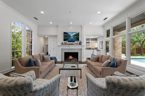 a living room with furniture a fireplace and a large window