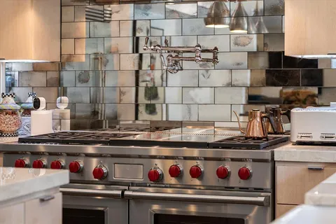 a stove top oven sitting inside of a kitchen
