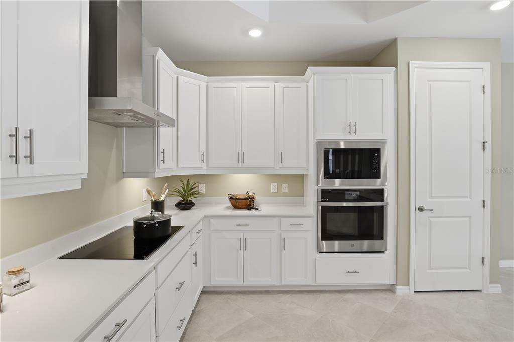 7153 Inlet Isles Lakewood Ranch, FL 34202 - Photo 9 of 26 a kitchen with stainless steel appliances white cabinets and white appliances