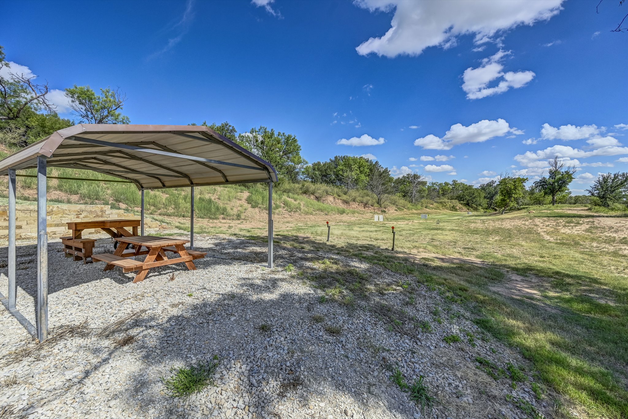 18601 County Road 214 Brookesmith, TX 76827 - Photo 37 of 39 a view of a yard with a table and chairs under an umbrella