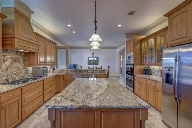 a kitchen with stainless steel appliances granite countertop a table chairs sink and cabinets