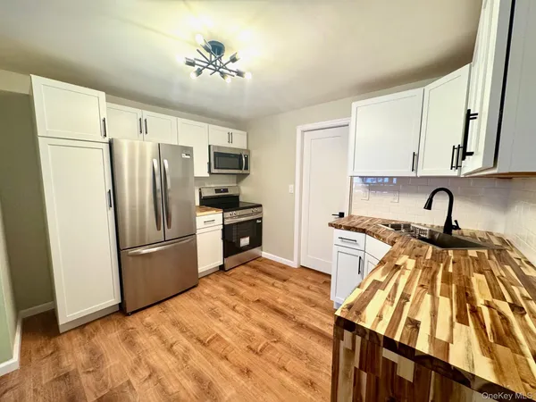 a kitchen with a refrigerator a stove and a sink