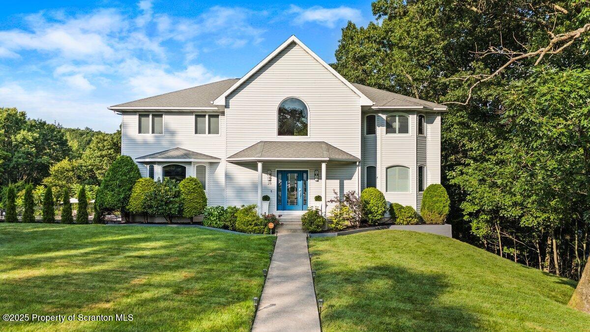 a front view of a house with a yard and potted plants