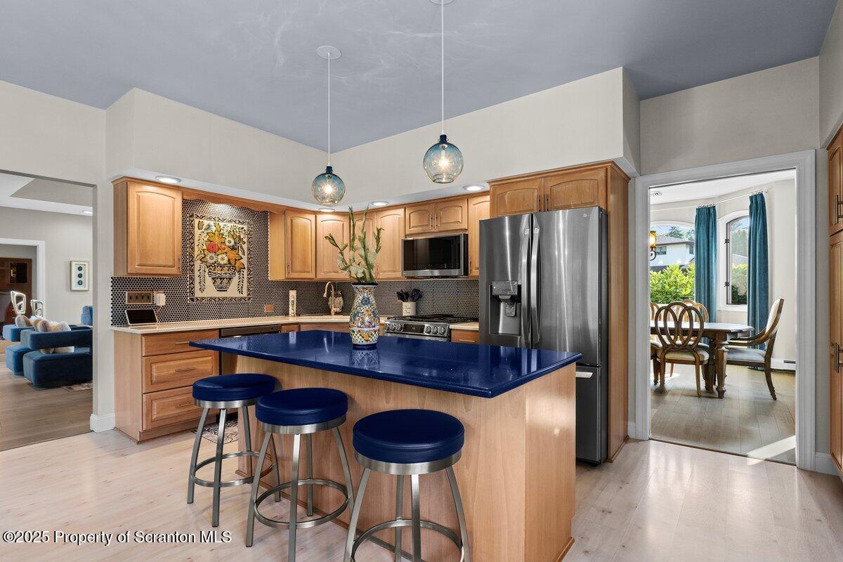 28 Ridgeview Drive Scranton, PA 18504 - Photo 24 of 55 a kitchen with stainless steel appliances granite countertop a refrigerator a stove a dining table and chairs with wooden floor