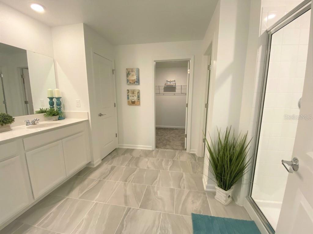 5010 Four Strand Court St. Cloud, FL 34772 - Photo 14 of 34 a bathroom with a sink a mirror and a shower