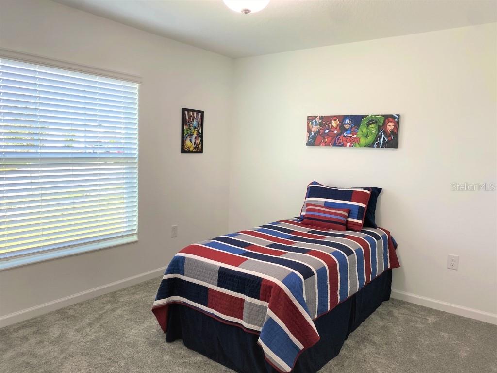 5010 Four Strand Court St. Cloud, FL 34772 - Photo 19 of 34 a bedroom with a bed and a window
