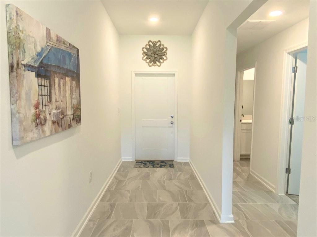 5010 Four Strand Court St. Cloud, FL 34772 - Photo 22 of 34 a view of a hallway with wooden floor and a bathroom