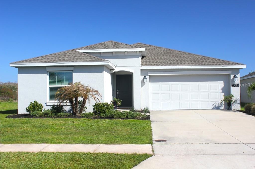 5010 Four Strand Court St. Cloud, FL 34772 - Photo 24 of 34 a front view of a house with a garden and plants