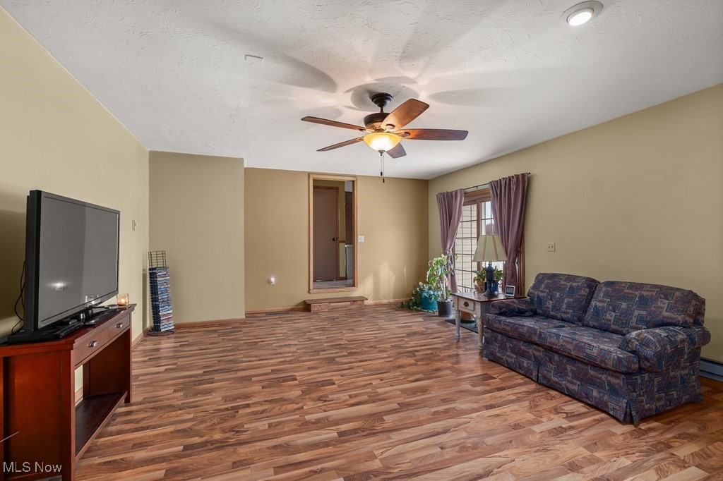 8238 Ruff Road West Salem, OH 44287 - Photo 13 of 27 Living area with a ceiling fan, a textured ceiling, baseboards, and wood finished floors