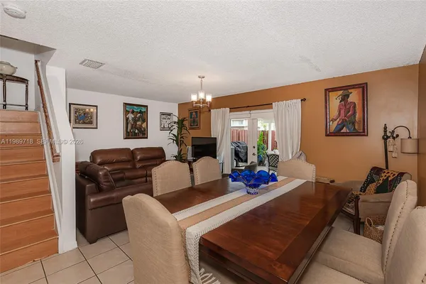 a living room with furniture a flat screen tv and a large window