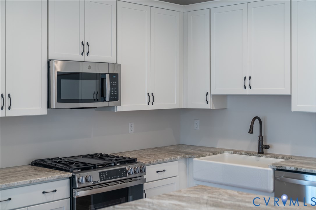 11219 Sparwood Road Chester, VA 23831 - Photo 22 of 28 a kitchen with granite countertop white cabinets and stainless steel appliances