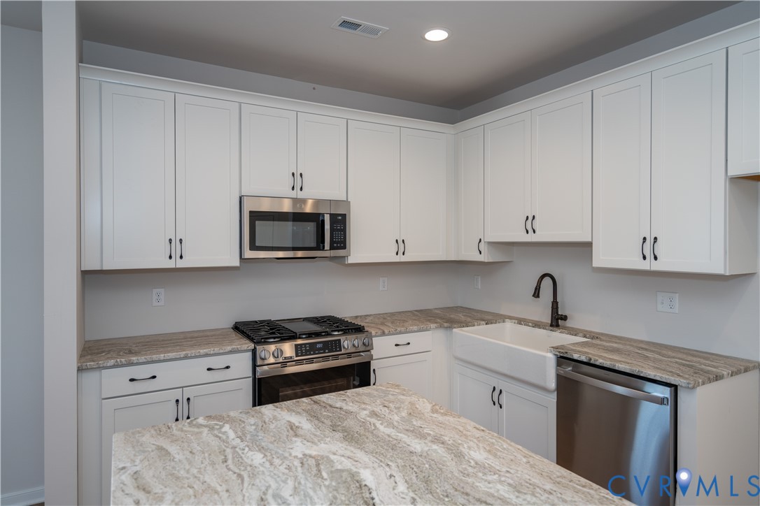 11219 Sparwood Road Chester, VA 23831 - Photo 6 of 28 a kitchen with granite countertop white cabinets and stainless steel appliances