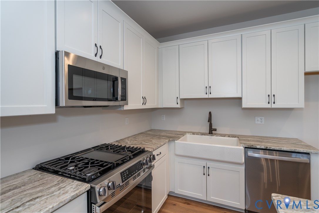 11219 Sparwood Road Chester, VA 23831 - Photo 7 of 28 a kitchen with granite countertop white cabinets stainless steel appliances and sink