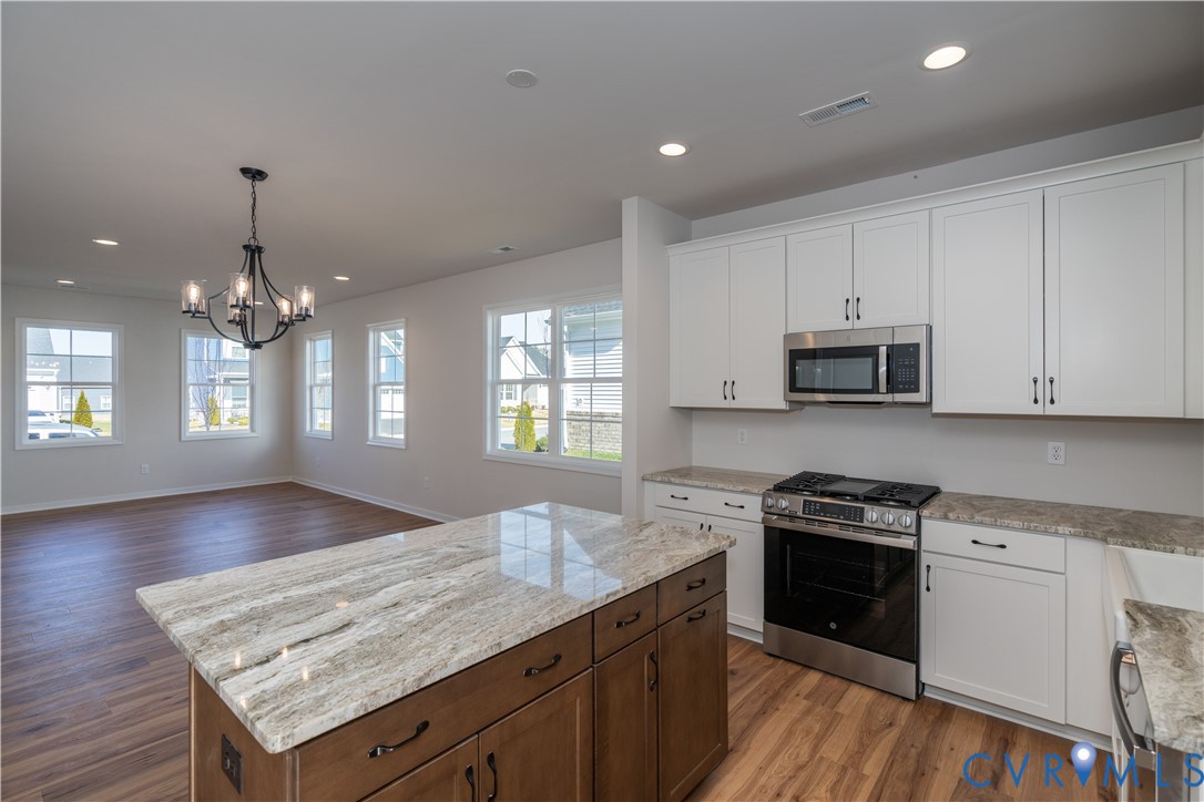 11219 Sparwood Road Chester, VA 23831 - Photo 8 of 28 a kitchen with stainless steel appliances granite countertop a stove top oven a sink dishwasher and microwave oven with cabinets