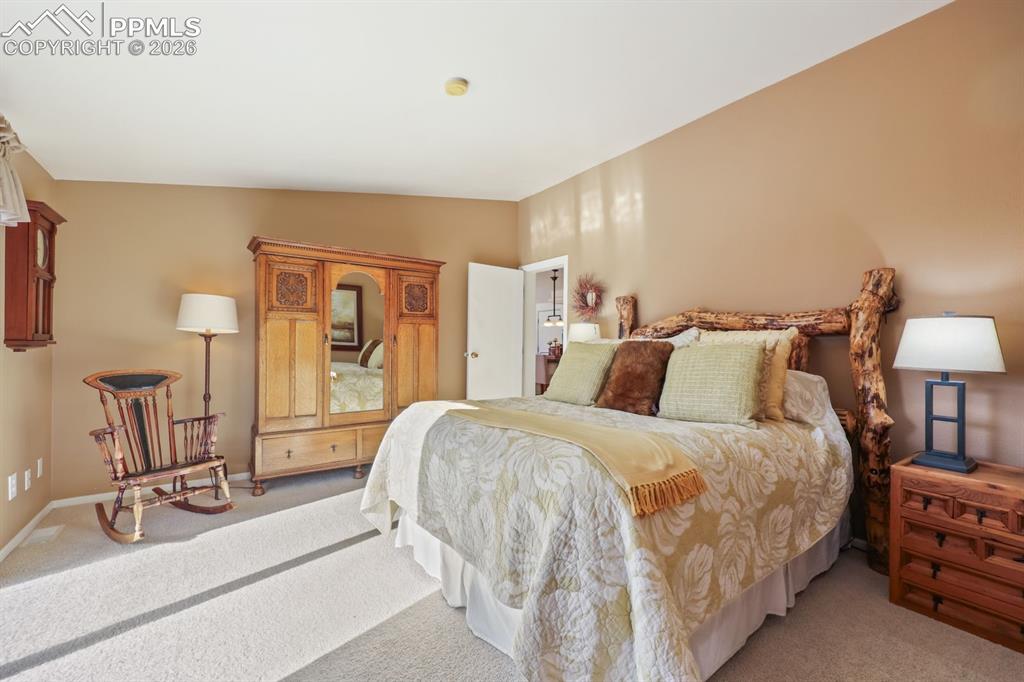 7260 Remington Road Como, CO 80432 - Photo 21 of 46 a bedroom with a bed a lamp and a large mirror