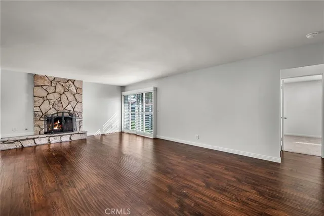 an empty room with wooden floor and a window