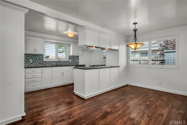 a kitchen with granite countertop white cabinets and white appliances