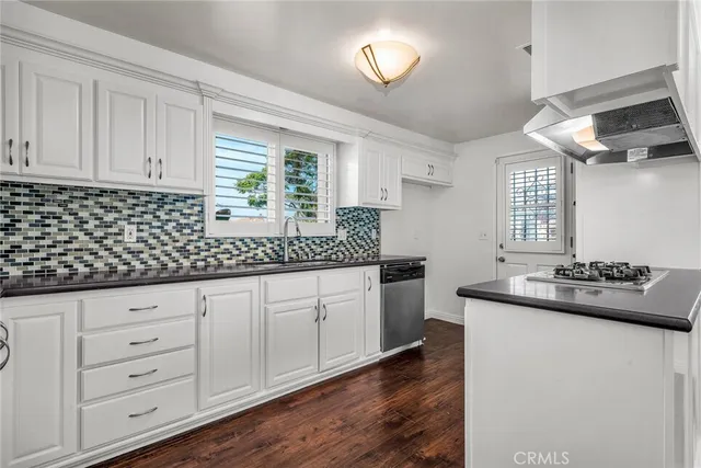 a kitchen with granite countertop a sink and dishwasher with wooden floor