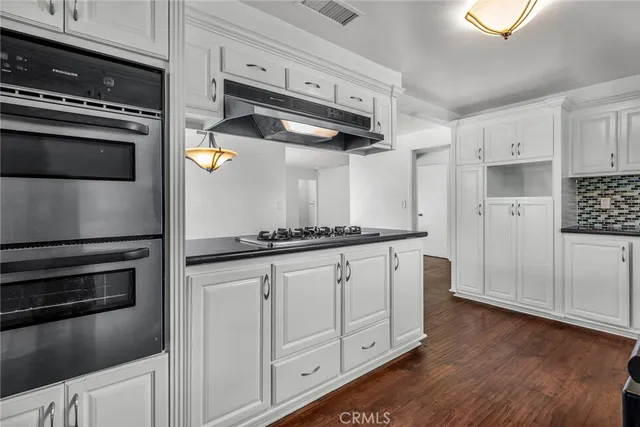 a kitchen with white cabinets and appliances