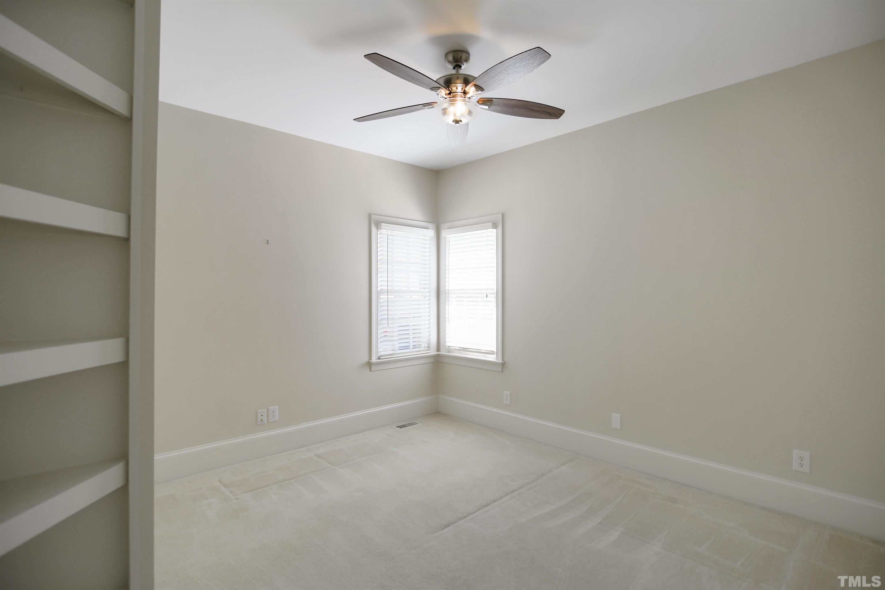 900 Tanworth Drive Raleigh, NC 27615 - Photo 15 of 26 an empty room with a window and a ceiling fan