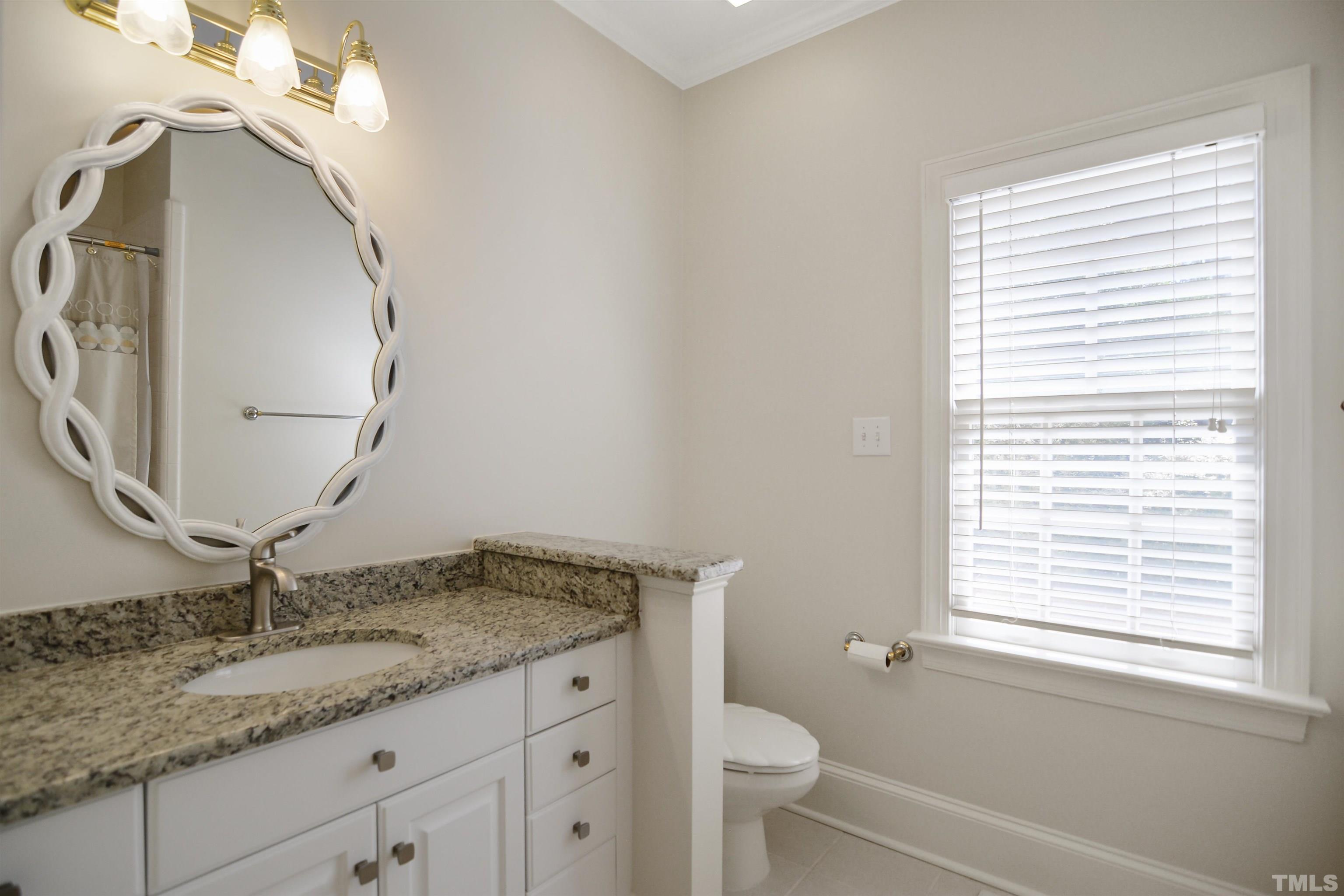 900 Tanworth Drive Raleigh, NC 27615 - Photo 16 of 26 a bathroom with a granite countertop sink and a mirror