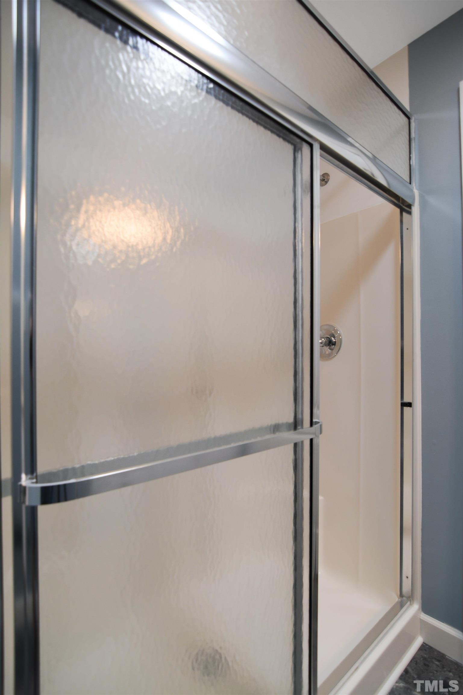 900 Tanworth Drive Raleigh, NC 27615 - Photo 21 of 26 a bathroom with a glass shower door