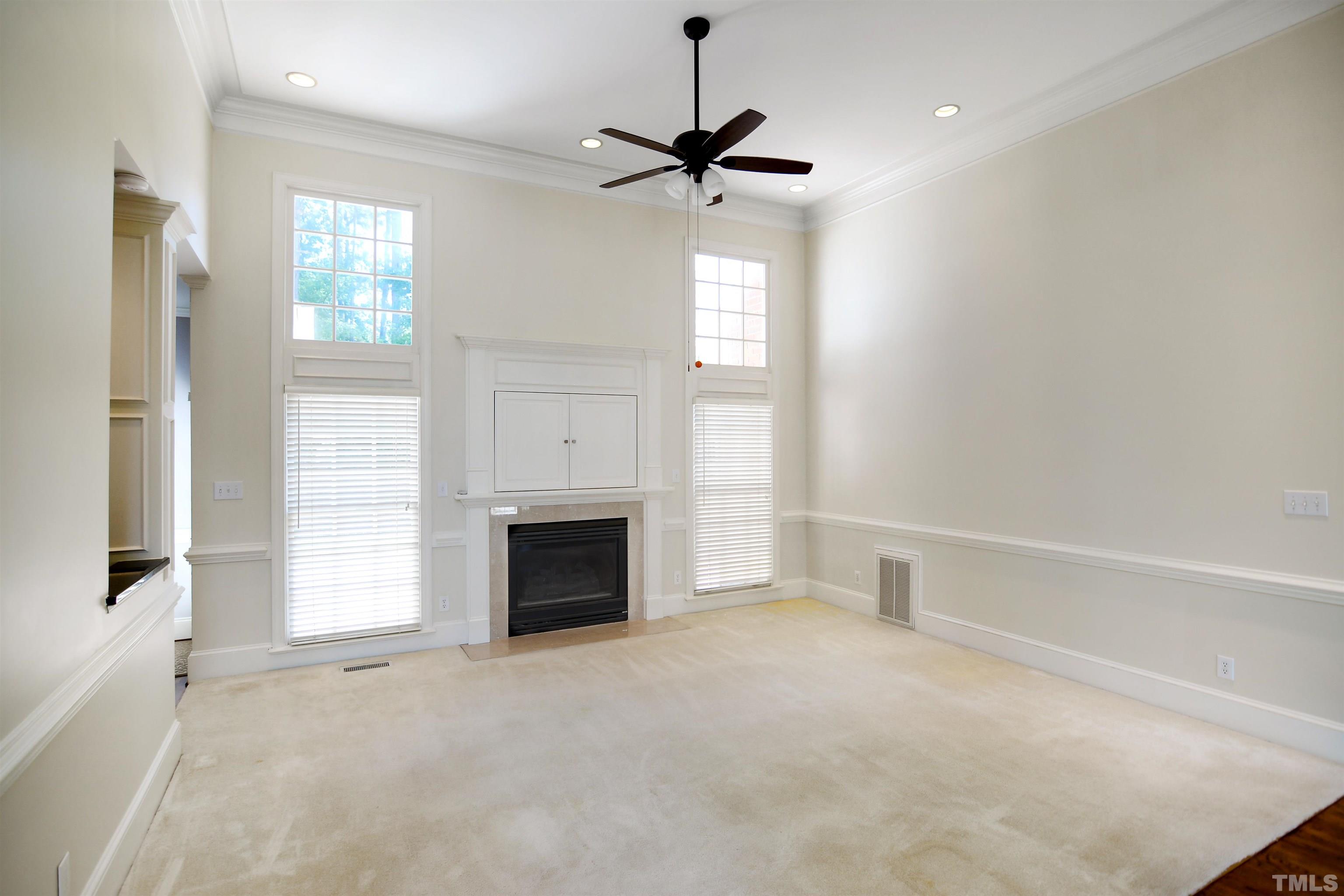 900 Tanworth Drive Raleigh, NC 27615 - Photo 4 of 26 a view of an empty room with a fireplace and a window