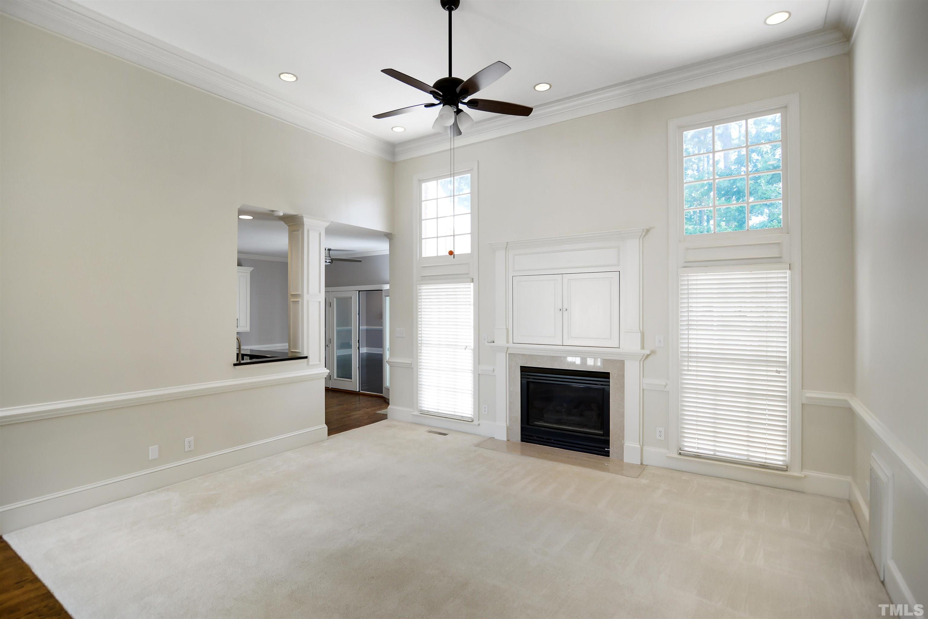 900 Tanworth Drive Raleigh, NC 27615 - Photo 5 of 26 a view of an empty room with a fireplace and a window