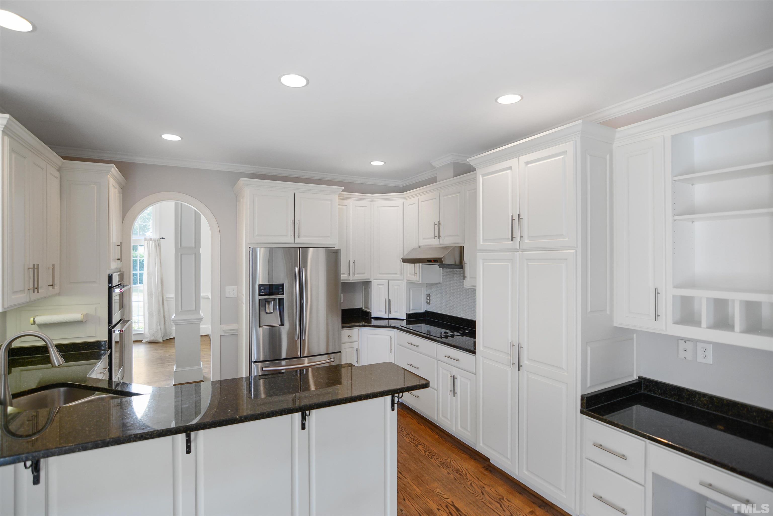 900 Tanworth Drive Raleigh, NC 27615 - Photo 6 of 26 a kitchen with stainless steel appliances kitchen island granite countertop a refrigerator and a sink