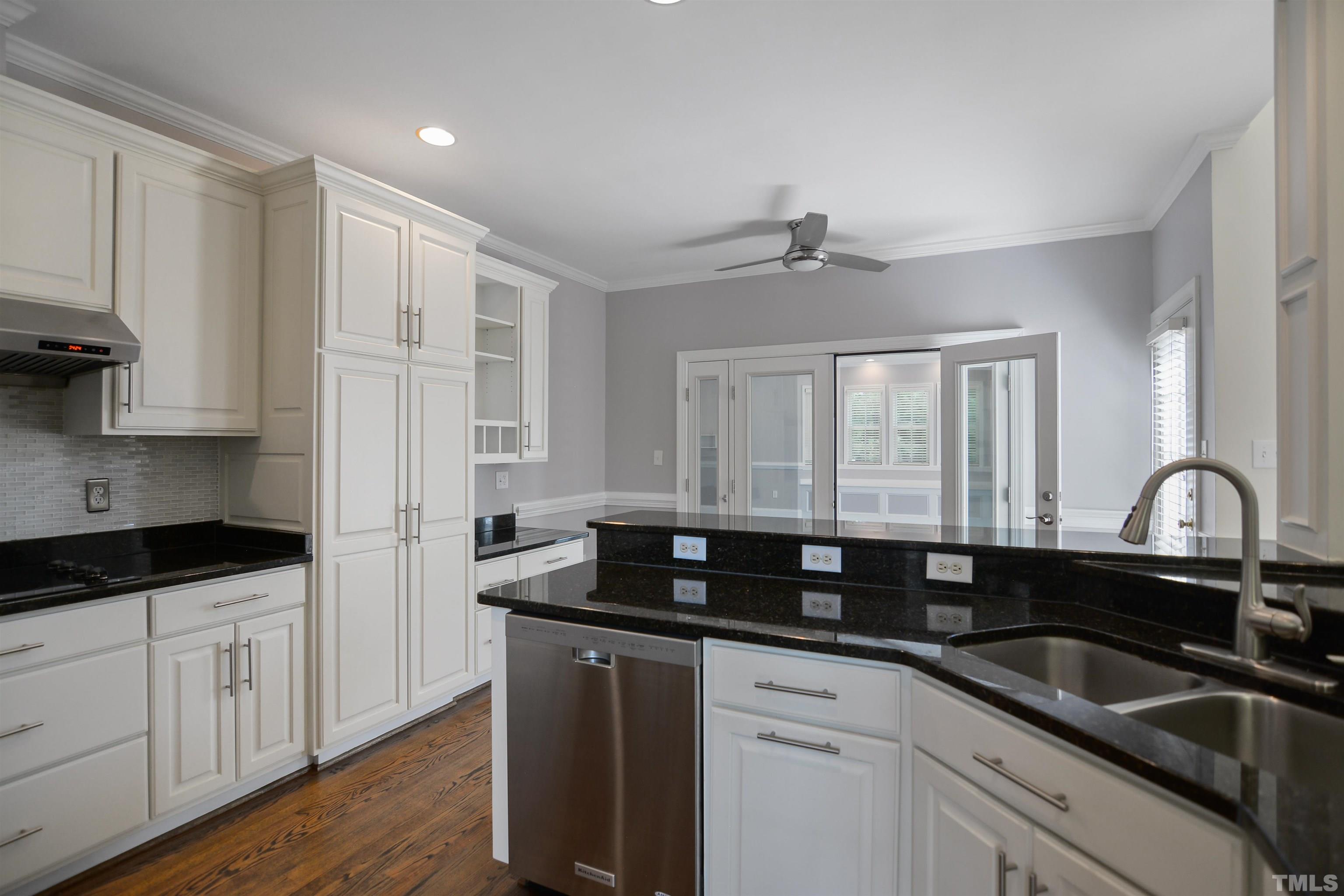 900 Tanworth Drive Raleigh, NC 27615 - Photo 8 of 26 a kitchen with granite countertop a sink white cabinets and a granite counter tops