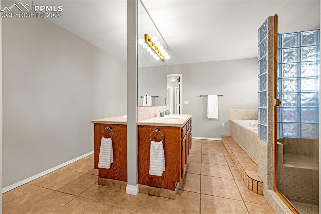 18475 Lower Lake Road Monument, CO 80132 - Photo 27 of 50 a bathroom with a sink a mirror and a bathtub