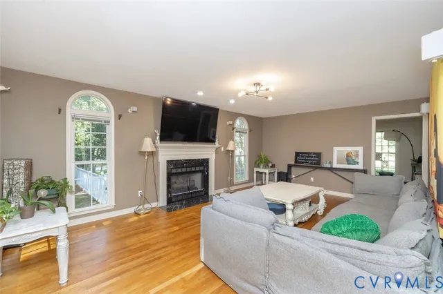 a living room with furniture a flat screen tv and a fireplace