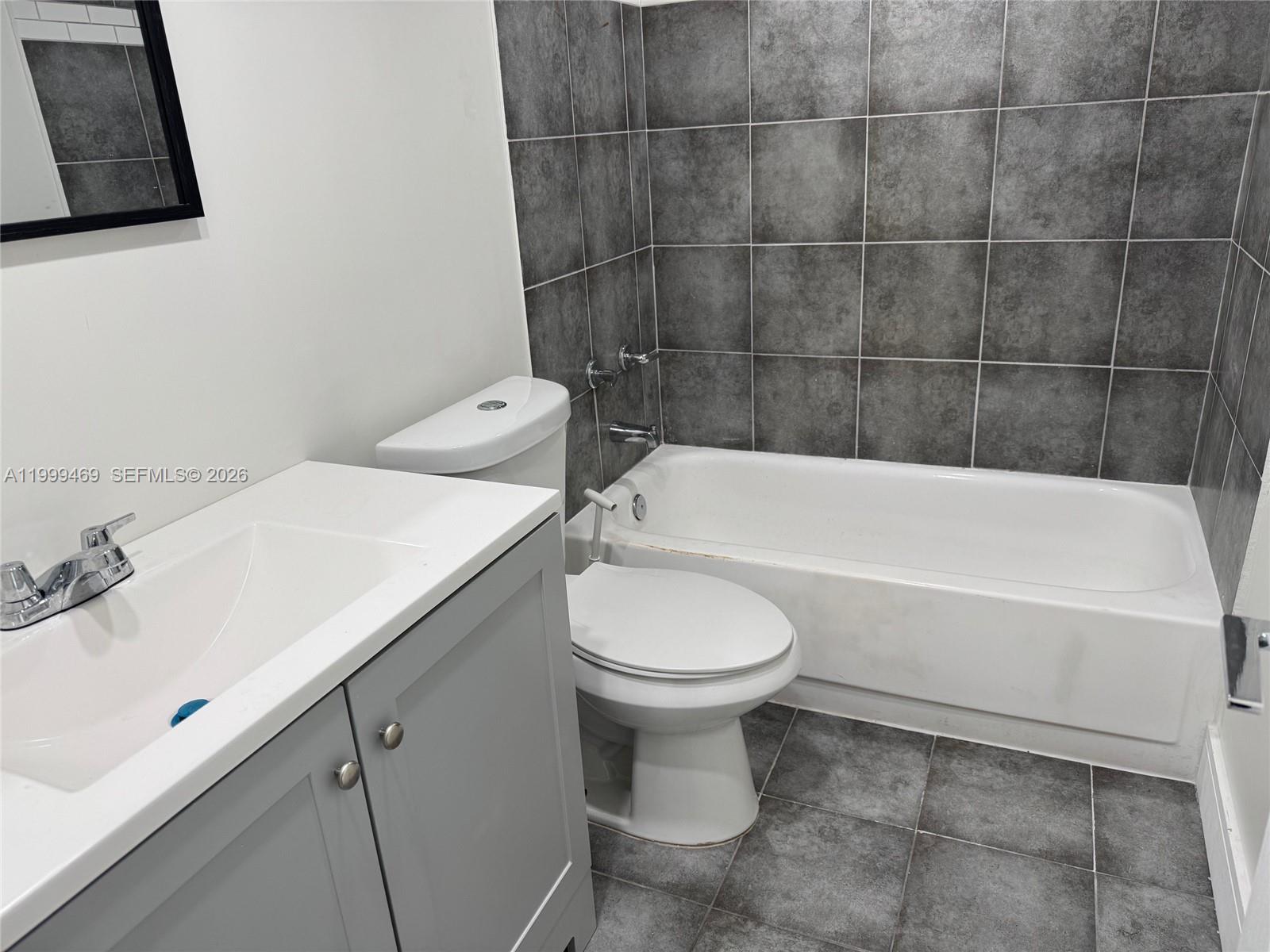 492 Northwest 165th Street, Unit C309 Miami, FL 33169 - Photo 6 of 15 a bathroom with a sink a toilet and bathtub