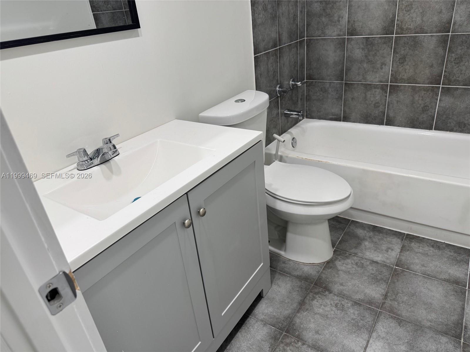 492 Northwest 165th Street, Unit C309 Miami, FL 33169 - Photo 7 of 15 a bathroom with a sink a toilet and bathtub