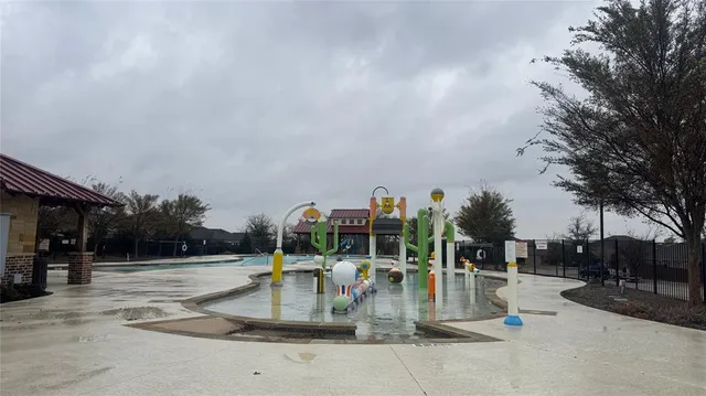 a view of a street with potted plants and large trees
