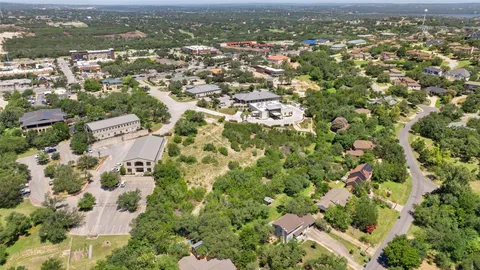 an aerial view of residential houses with outdoor space and trees