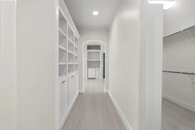 a view of a hallway with wooden floor and entryway