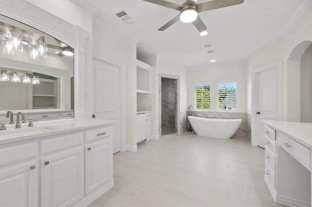 a spacious bathroom with a double vanity sink a mirror and a bathtub