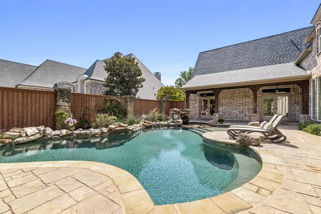 a view of a house with backyard swimming pool and sitting area